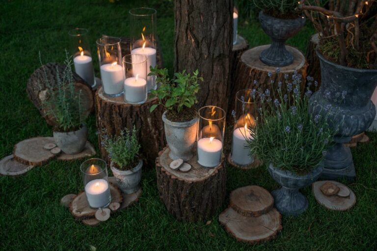 Tall vases with white candles stand on the blocks in the garden